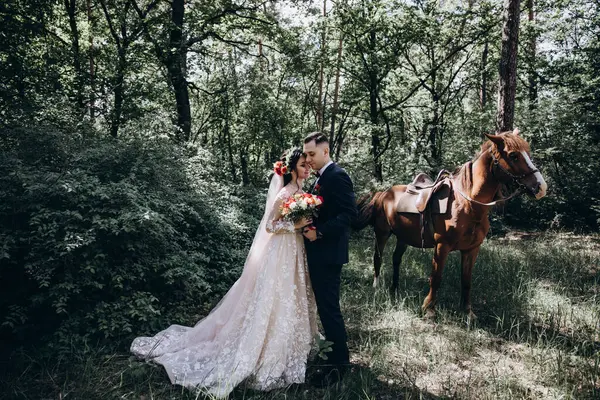 Ormanda atı olan mutlu gelin ve damat.               