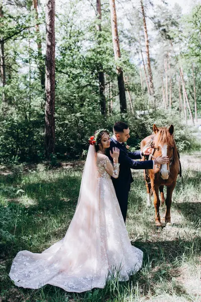 Ormanda atı olan mutlu gelin ve damat.               