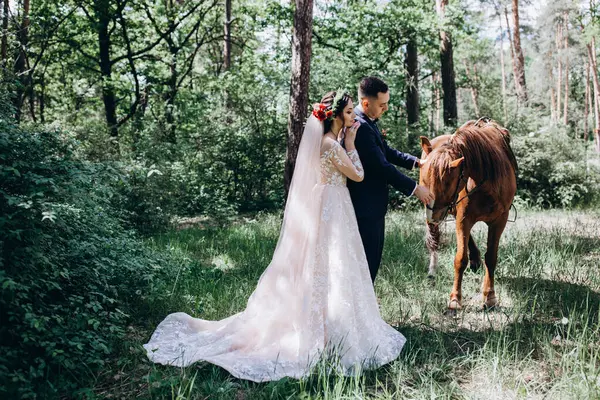 Ormanda atı olan mutlu gelin ve damat.               