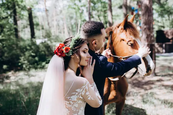 Ormanda atı olan mutlu gelin ve damat.               