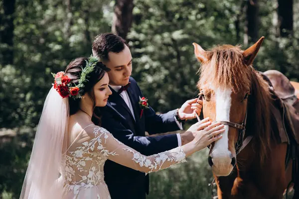 Ormanda atı olan mutlu gelin ve damat.               