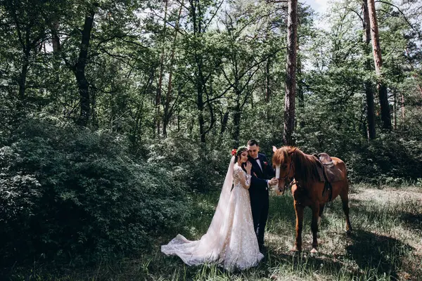 Ormanda atı olan mutlu gelin ve damat.               