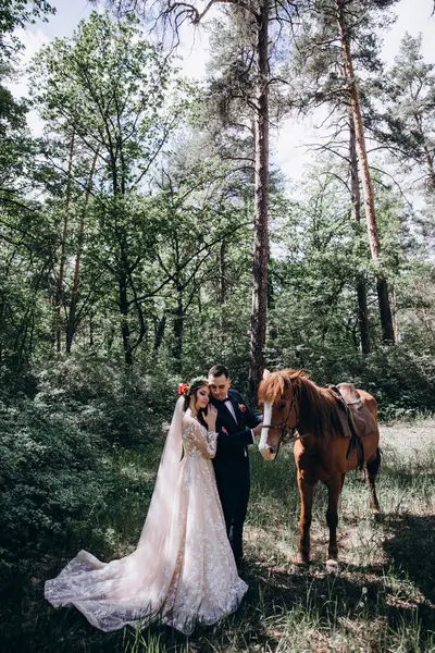 Ormanda atı olan mutlu gelin ve damat.               