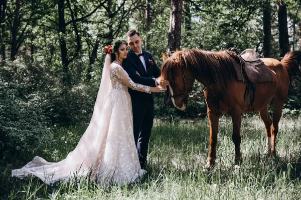 Ormanda atı olan mutlu gelin ve damat.               
