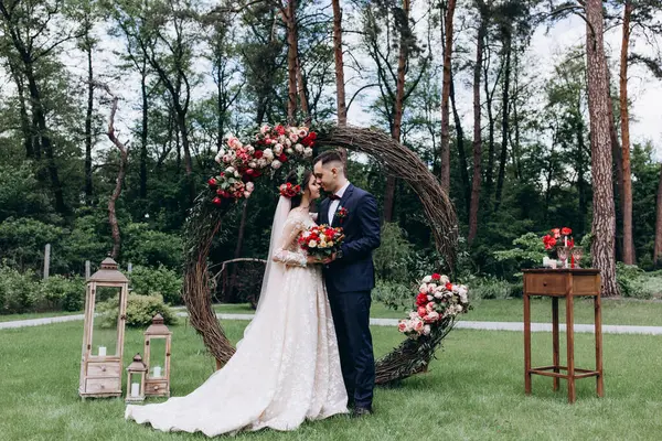 Gelin ve damat açık havada öpüşüyorlar.     