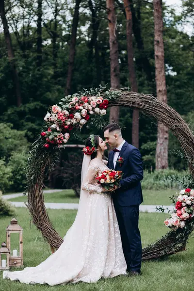 Gelin ve damat açık havada öpüşüyorlar.     