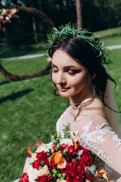 Yeşil yaz parkında poz veren güzel gelinin portresi.            