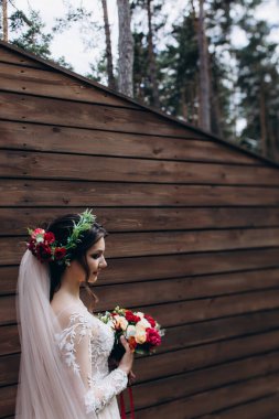 Dışarıda düğün buketi tutan güzel gelinin portresi.     