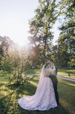 Mutlu genç çift gün batımında parkta poz veriyor.             