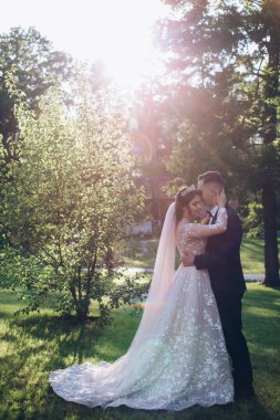 Mutlu genç çift gün batımında parkta poz veriyor.             