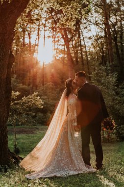 Mutlu genç çift gün batımında parkta poz veriyor.             