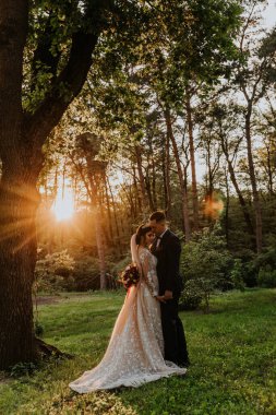 Mutlu genç çift gün batımında parkta poz veriyor.             