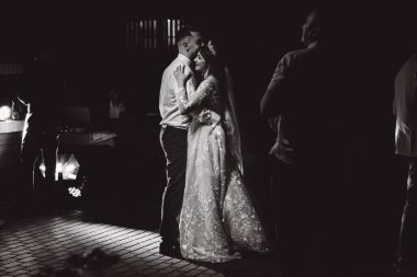 Gece dans eden bir çiftin siyah beyaz görüntüsü.