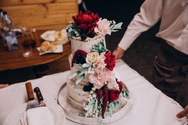 Restoranda çiçeklerle süslenmiş düğün pastası.