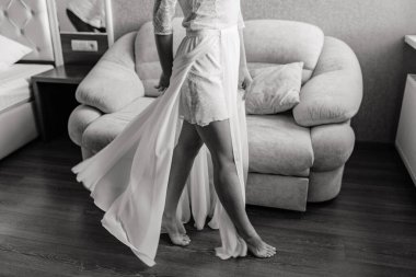 Gelinin düşük kesimi beyaz elbiseli, odada yürüyen, düğün sabahı           