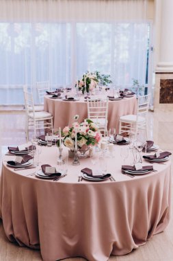 Düğün resepsiyonunda çiçekler ve mumlarla güzel bir masa.                 