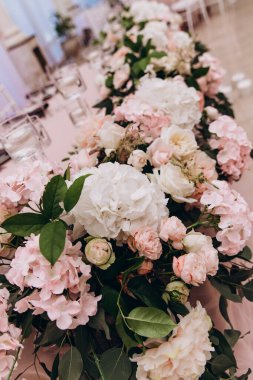 Güzel çiçeklerle süslenmiş düğün masası.