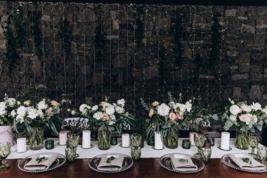 Düğün resepsiyonunda çiçekler ve mumlarla güzel bir masa.                 