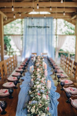 Düğün resepsiyonunda çiçekler ve mumlarla güzel bir masa.                 