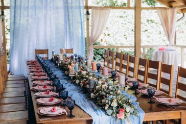 Düğün resepsiyonunda çiçekler ve mumlarla güzel bir masa.                 