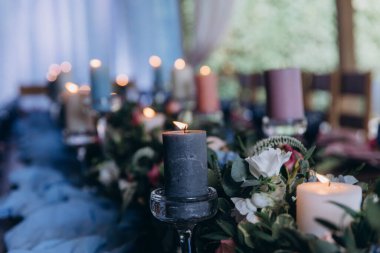 Düğün resepsiyonunda çiçekler ve mumlarla güzel bir masa.                 