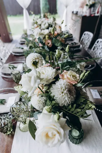 Düğün resepsiyonunda çiçekler ve mumlarla güzel bir masa.                 