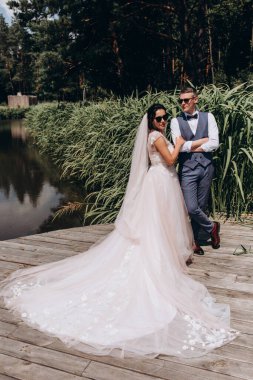 Mutlu gelin ve damat göldeki ahşap iskelede poz veriyor.               