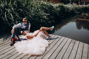 Mutlu gelin ve damat göldeki ahşap iskelede poz veriyor.               