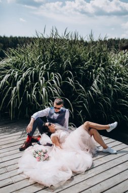 Mutlu gelin ve damat göldeki ahşap iskelede poz veriyor.               