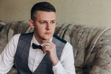 Odada oturan zarif genç adamın portresi.  