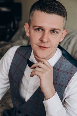 Odada oturan zarif genç adamın portresi.  