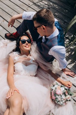 Mutlu genç bir çift yaz vakti tahta iskelede dinleniyor.