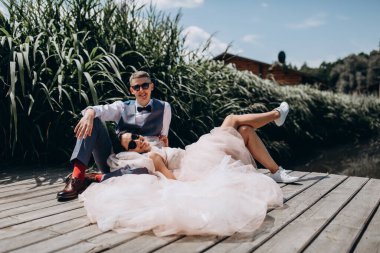 Mutlu gelin ve damat göldeki ahşap iskelede poz veriyor.               