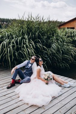 Mutlu gelin ve damat göldeki ahşap iskelede poz veriyor.               