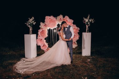 Güzel genç gelin ve damat düğün günlerinde dışarıda poz veriyorlar..