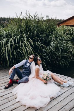 Nehrin kenarında oturan mutlu gelin ve damat. Birbirine aşık çift..