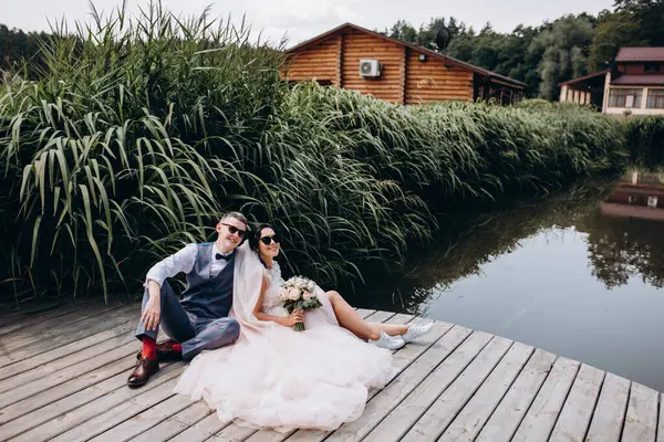 Mutlu gelin ve damat göldeki ahşap iskelede poz veriyor.               