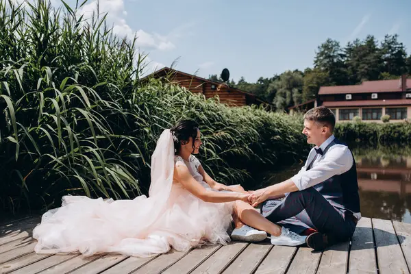 Mutlu gelin ve damat göldeki ahşap iskelede poz veriyor.               