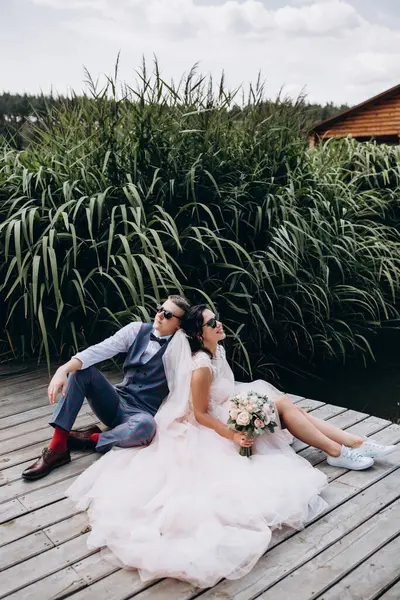 Nehrin kenarında oturan mutlu gelin ve damat. Birbirine aşık çift..