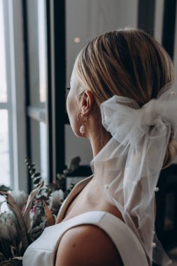 Çekici genç gelinin portresi güzel bir düğün buketi tutuyor.               