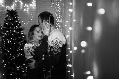 Genç ve mutlu bir çift Noel 'de birbirlerine sarılıyorlar.