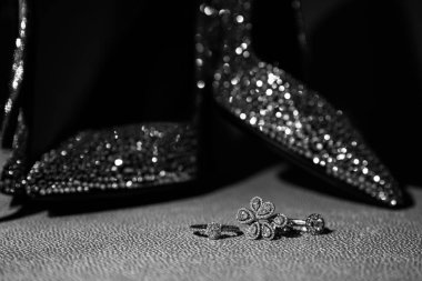 Güzel düğün ayakkabıları ve mücevherlerinin yakın plan görüntüsü, siyah beyaz