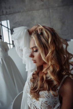 Banyoda poz veren beyaz iç çamaşırlı güzel bir kadın. Beyaz iç çamaşırlı seksi kız. Sabahleyin genç gelin                  