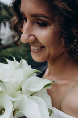 Güzel, mutlu, genç gelin elinde düğün buketi