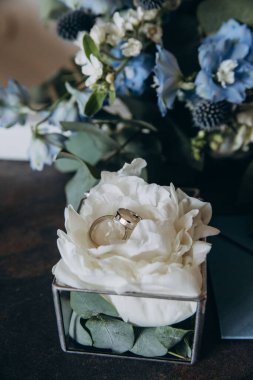 Lüks alyansların ve güzel narin çiçeklerin yakın çekimi.       