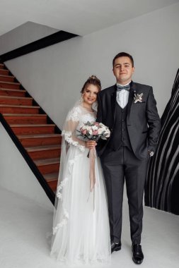 Mutlu genç gelin ve damat kameraya gülümsüyor.