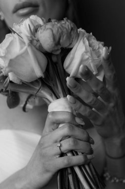 Genç gelinin elinde güzel çiçeklerden bir buket tuttuğu yakın plan görüntüsü.                  