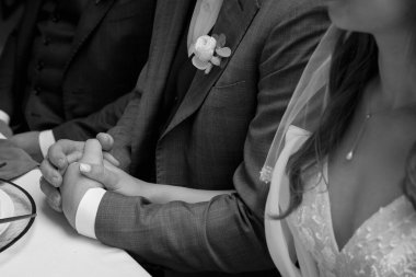 Gelin ve damat düğün gününde yüzüklerle el ele tutuşuyorlar..