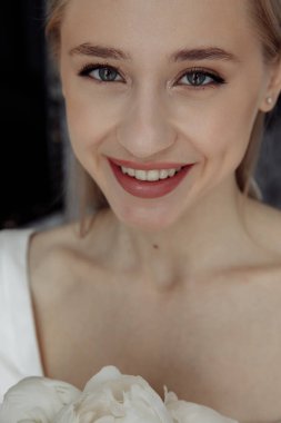 Genç ve güzel mutlu gelin kameraya gülümsüyor.