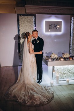 Güzel çift düğün resepsiyonunda sarılıp öpüşüyor.